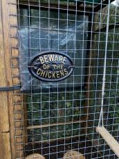'A beware of the chickens' sign attached to an enclosure