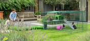 Trois lapins dans un parc pour lapins Omlet Zippi avec Zippi plateformes, abri vert Zippi et Zippi tunnel connecté