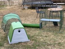 A rabbit installation, including a hutch and run connected to an enclosure by a green tunnel