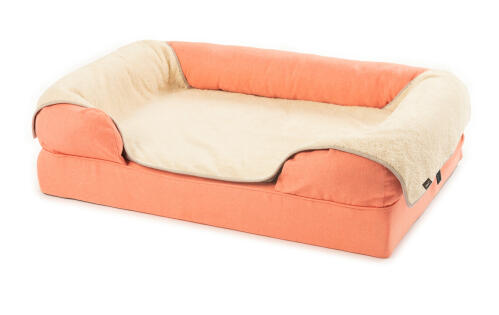 a large 42 pink memory foam bolster bed with a cream plush blanket over the top