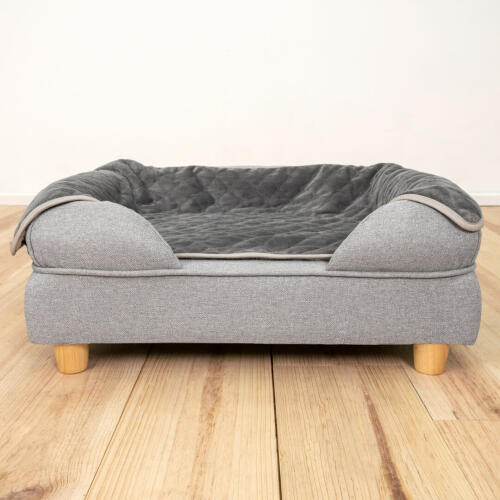 An Omlet bolster dog bed with feet and a luxury soft blanket.