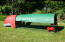 Röd Eglu Classic hönshus med löpning och grönt skydd i full längd som ger skugga i trädgården