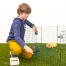 En pojke som öppnar en marsvinsgård med två marsvin i den.