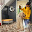 Mädchen nimmt hund für spaziergang mit Omlet Topology hundebett mit sitzsack topper und weiße schiene füße im hintergrund