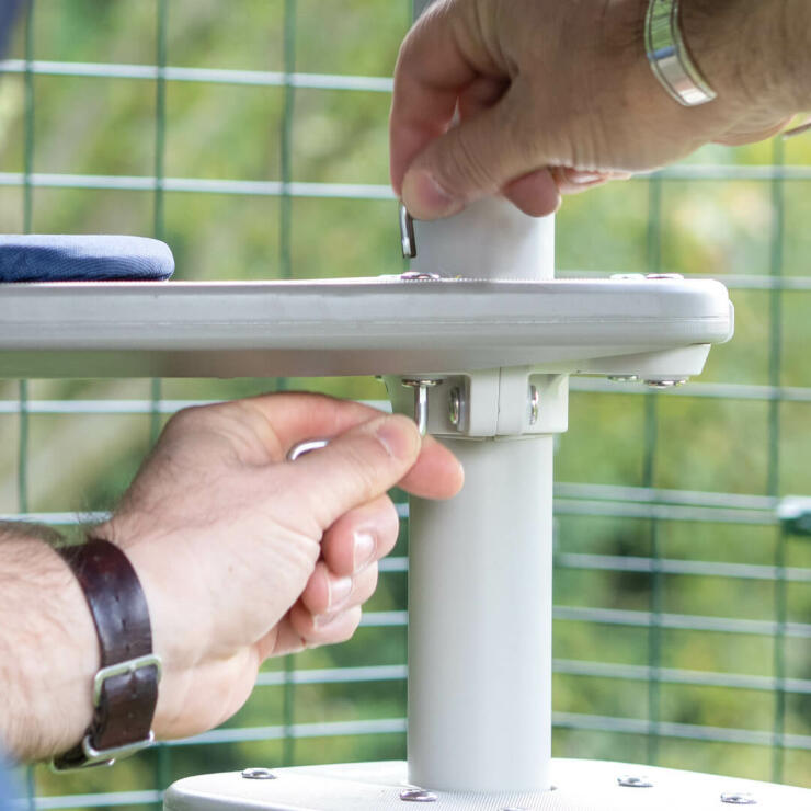 Man attaching the platform accessory to the pole to create a personalised outdoor cat tree