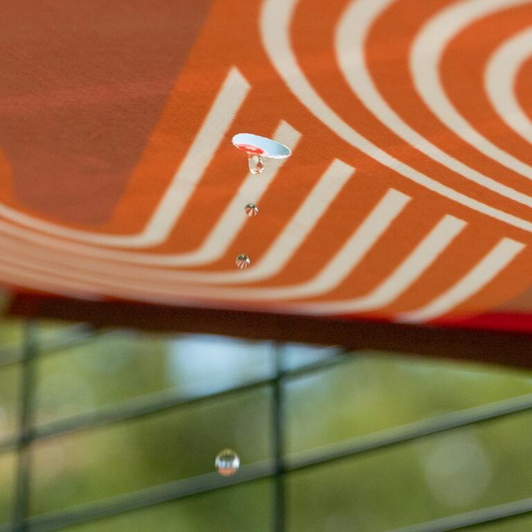 Close-up van water dat van Omlet rode waterdichte kattenplank valt