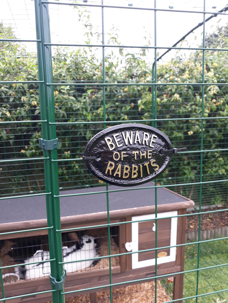 Omlet gåtur i kanin løbegård med træbur og kanin og skiltet "pas på kaninerne" på