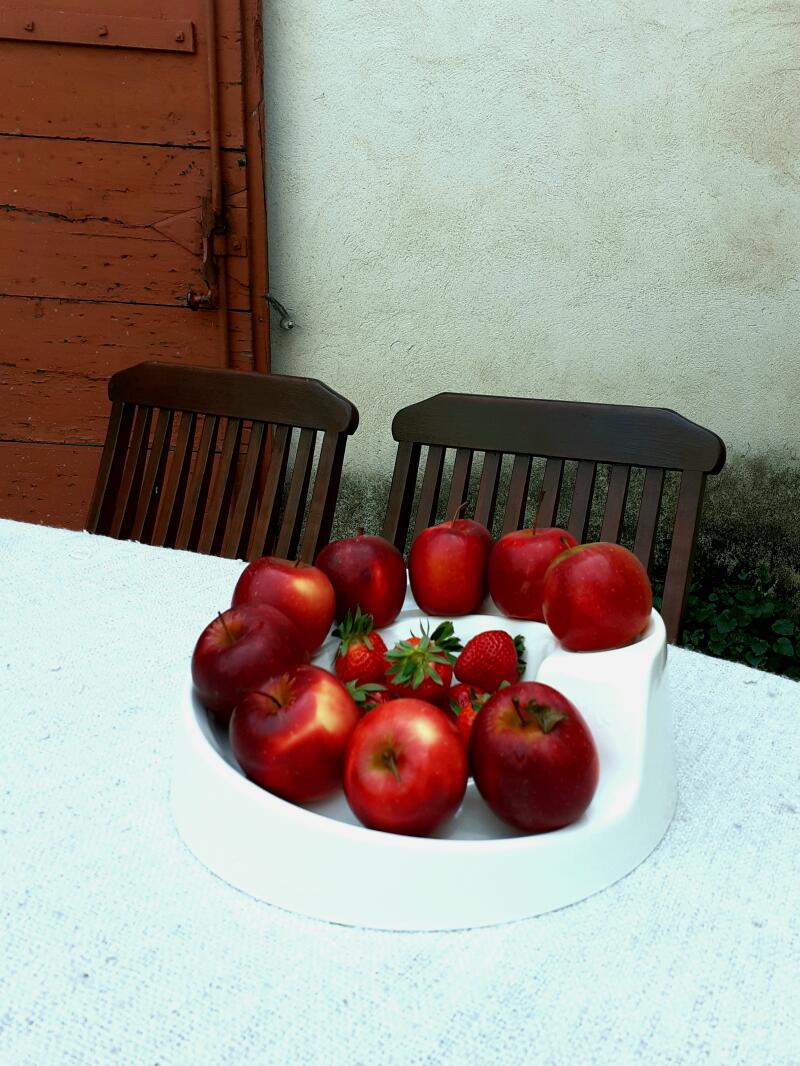 Apples on an egg helter-skelter on a table in a garden
