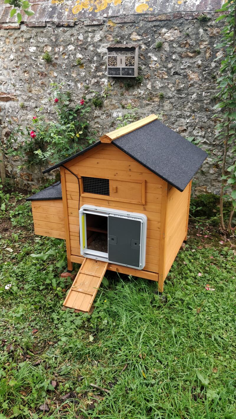 An Automatic chicken coop door on a  wooden hen house