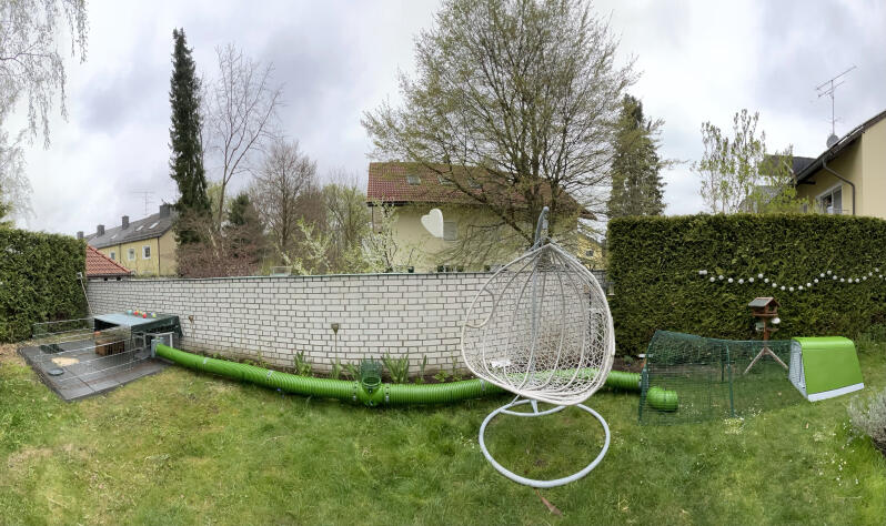 Green Eglu Rabbit Hutch with run connected to a run with the Omlet Zippi Tunnels in the garden