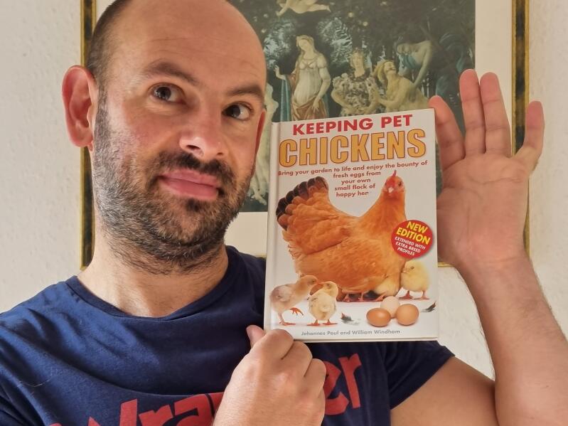 A person holding a chicken keeping book