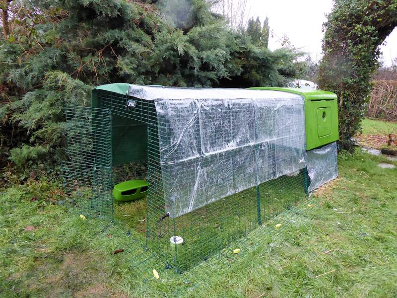 a eglu cube chicken coop with a run attached and a cover over the top