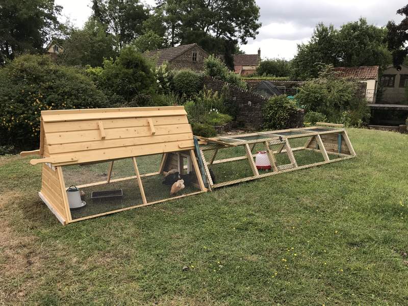 A wooden coop attached to a DIY run