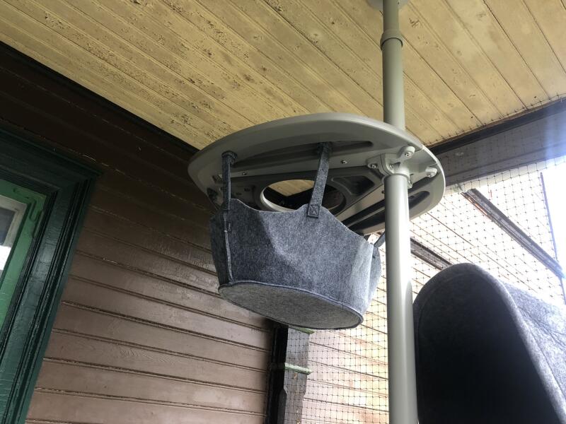 A hammock on a platform installed on an outdoor cat tree