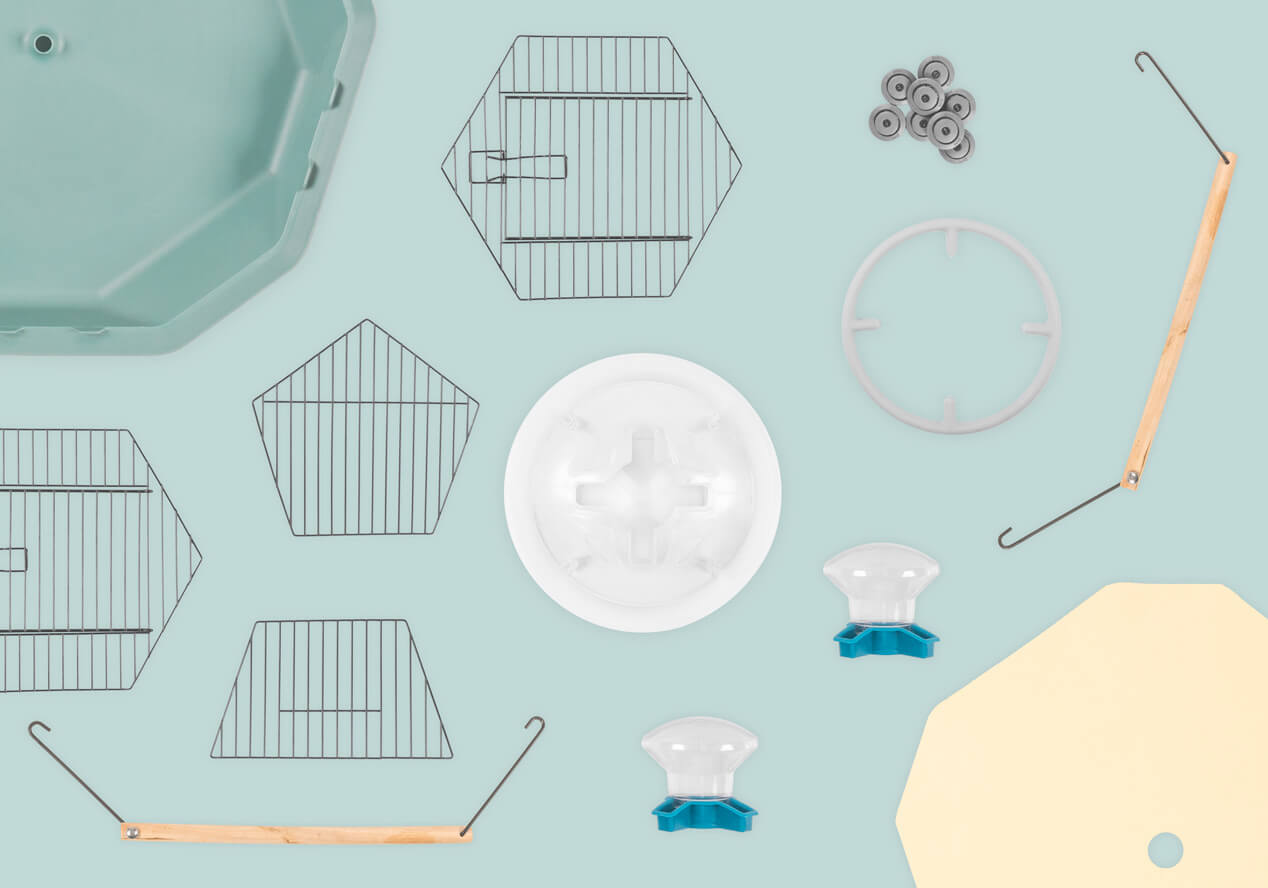 An overview of the free accessories included with the Geo Bird Cage including two perches, ten disposable bird cage liners, and the bird feeder and drinker assembly complete with detachable perching ring