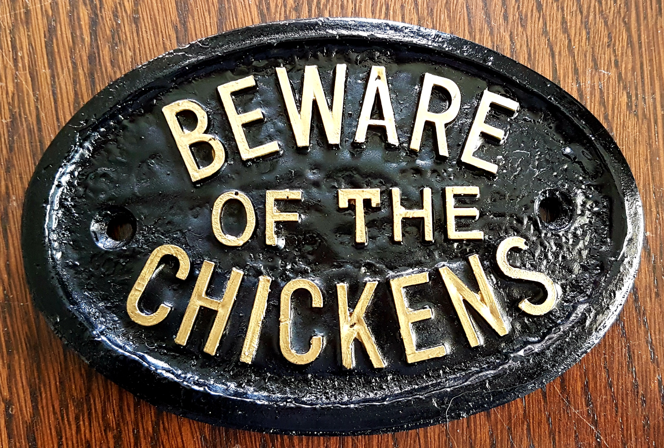 Cartel negro de cuidado con los pollos con letras blancas